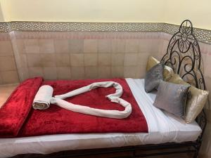 Una cama con un corazón hecho de toallas en Riad Douja, en Marrakech