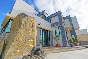 a house with a rock in front of it at 忘憂海HappinesSea in Xiyu