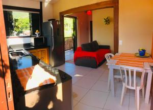 a kitchen and living room with a table and a couch at Casa no Centro da Ilhabela - Vila - SP in Ilhabela