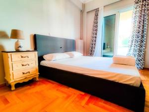 1 dormitorio con 1 cama, vestidor y ventana en Spacious 2bedroom apartment near Athens and sea, en Atenas