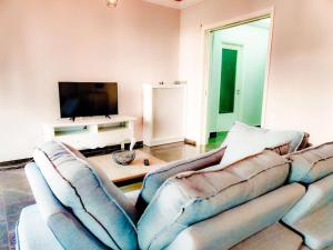 sala de estar con sofá y TV de pantalla plana en Spacious 2bedroom apartment near Athens and sea, en Atenas