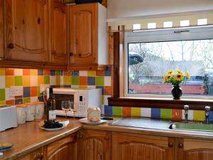a kitchen with a counter with a window and a sink at Riverside Cottage in Drumnadrochit