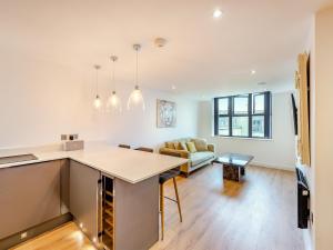 a kitchen and living room with a table and a couch at Queens Bridge Apartment in Ramsgate