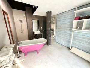 ein Badezimmer mit einer rosa Badewanne und einem Waschbecken in der Unterkunft Villa 250m2 avec piscine – En pleine nature, parc de 6ha in Quéven