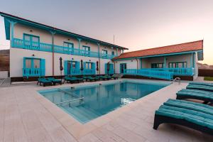 a hotel with a swimming pool in front of a building at Vila Mavis-cazare cu piscina incalzita & jacuzzi in Mahmudia