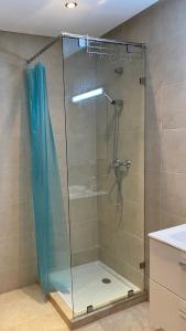 um chuveiro com uma porta de vidro na casa de banho em Apartement Marina Zina, Agadir em Agadir