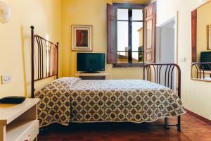 a bedroom with a bed and a television at Hotel Savoia e Campana in Montecatini Terme