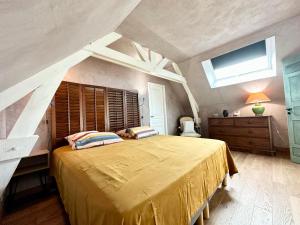 ein Schlafzimmer mit einem großen Bett mit gelber Tagesdecke in der Unterkunft Villa 250m2 avec piscine – En pleine nature, parc de 6ha in Quéven