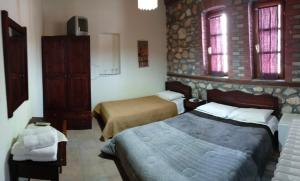 a hotel room with two beds and two windows at Varnous Hotel in Agios Germanos