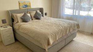 a bedroom with a large bed with pillows and a window at Apartement Marina Zina, Agadir in Agadir