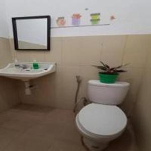 y baño con aseo blanco y lavamanos. en Brak Homestay, en Sukobumi