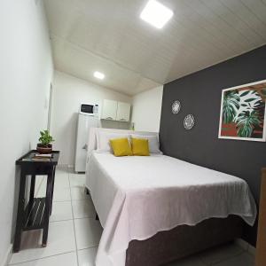 um quarto com uma cama grande e almofadas amarelas em Temporada Cuiabana em Cuiabá