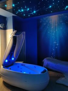 baño azul con bañera y cama en Hotel Forum Fitness Spa & Wellness, en Lublin
