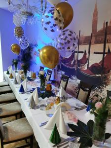 einem langen Tisch mit Ballons und Platten darauf in der Unterkunft Hotel Forum Fitness Spa & Wellness in Lublin