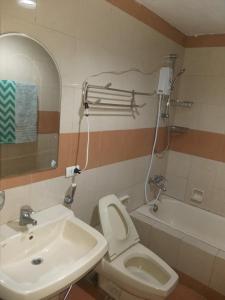 a bathroom with a white toilet and a sink at MANILA BAY EXECUTIVE SUITE pearl of orient in Manila