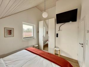 a bedroom with a bed and a flat screen tv at Das Vechtehaus n - Nordhorn in Nordhorn