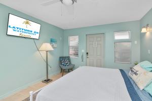 - une chambre avec un lit blanc et un mur bleu dans l'établissement Latitude 26 Waterfront Boutique Resort - Bonita Springs, à Bonita Springs
