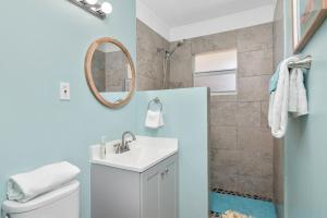 a bathroom with a toilet and a sink and a mirror at Latitude 26 Waterfront Boutique Resort - Bonita Springs in Bonita Springs