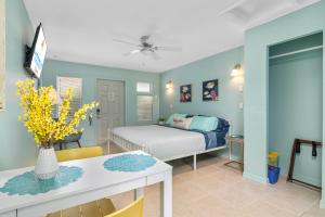 1 dormitorio con 1 cama, mesa y sillas en Latitude 26 Waterfront Boutique Resort - Bonita Springs en Bonita Springs