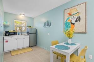 a kitchen with a white table and a refrigerator at Latitude 26 Waterfront Boutique Resort - Bonita Springs in Bonita Springs