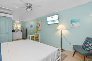 a bedroom with a white bed and a kitchen at Latitude 26 Waterfront Boutique Resort - Bonita Springs in Bonita Springs