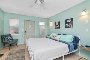a bedroom with a white bed and a chair at Latitude 26 Waterfront Boutique Resort - Bonita Springs in Bonita Springs
