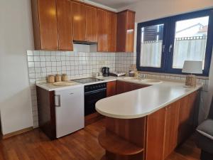 eine Küche mit Holzschränken und einer weißen Arbeitsplatte in der Unterkunft Apartments Katarina - New renovated in Rovinj