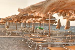 un gruppo di sedie e ombrelloni su una spiaggia di Sale Hotel a Posada