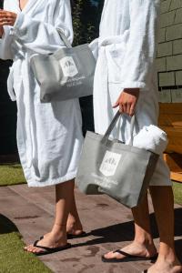 フォルガリダにあるHotel Derbyの二人の女性がタオルをかけて買い物袋を持って立っている