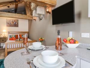 a kitchen with a table with a tv on the wall at Bess Cottage in Hebden Bridge