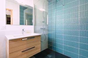 ein Badezimmer mit einem Waschbecken und einer Dusche mit blauen Fliesen in der Unterkunft *** Le studio *** 15 minutes de Bordeaux *** in Fargues-Saint-Hilaire