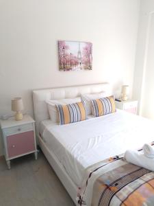 a bedroom with a large white bed with two pillows at IOKASTI STUDIOS 5 in Andros
