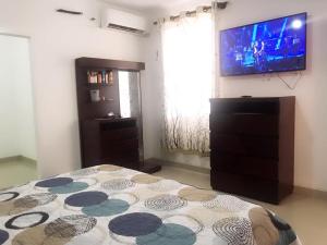1 dormitorio con 1 cama y TV de pantalla plana en Casa en condominio el dorado, en Trinidad