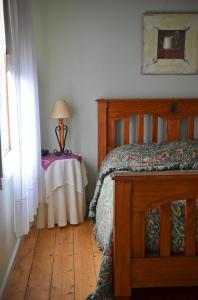 1 dormitorio con 1 cama y 1 mesa con lámpara en Leafield Cottages, en Dixons Creek