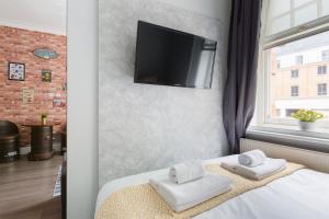 a bedroom with a bed with towels and a flat screen tv at The Victoria Flats in London