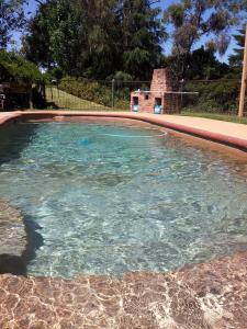 una piscina de agua azul en un patio en Leafield Cottages, en Dixons Creek
