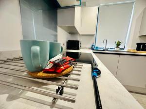 eine Küche mit einer Theke mit einer blauen Tasse drauf in der Unterkunft Hemel Apartments - Sea Breeze in Hemel Hempstead