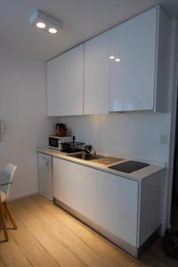 uma cozinha branca com armários brancos e um lavatório em Babel Alto em Buenos Aires