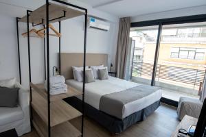 um quarto de hotel com uma cama e uma grande janela em Babel Alto em Buenos Aires