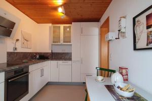 uma cozinha com armários brancos e uma mesa com uma tigela em *Black Forest Schwarzwaldtanne* em Schluchsee