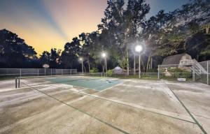 an empty tennis court at night with lights at Cottage in the woods at Emerald Lakes Estate in St. Augustine