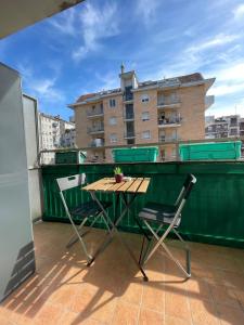 un tavolo e sedie su un balcone con un edificio di Gardone Apartment - ampio Appartamento con 2 camere da letto - Comodo per Duomo! a Milano