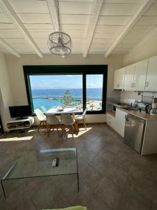 a kitchen with a table and chairs and a large window at Akteon Rooms in Agia Galini