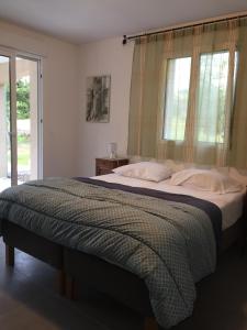 sypialnia z dużym łóżkiem i oknem w obiekcie Villa La Barbière w mieście Sallelles