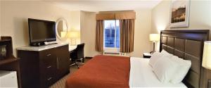 a hotel room with a bed and a flat screen tv at Home Inn & Suites in Montgomery +28 photos