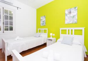 una camera con due letti e una parete verde di Villa Asarel by Sonne Villas a Cala Galdana