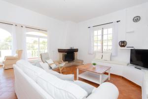 a living room with white furniture and a fireplace at Villa Asarel by Sonne Villas in Cala Galdana