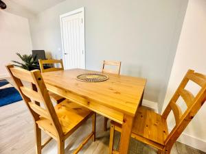 einen Holztisch und Stühle in einem Zimmer in der Unterkunft Hemel Apartments - Sea Breeze in Hemel Hempstead