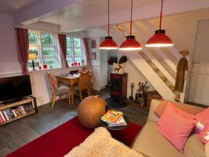 a living room with a couch and a staircase at Ferienhaus unter Reet im Heidedorf Sankt Dionys bei Lüneburg in Sankt Dionys