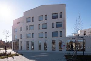 um edifício branco com janelas do lado em The Originals Boutique Hôtel Amiens Sud em Amiens